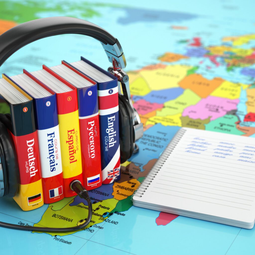 Libri di lingue con cuffie su una mappa del mondo.