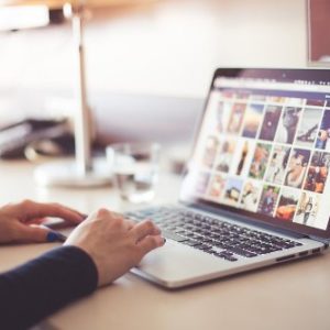 Persona che utilizza un laptop su un tavolo in un ambiente di lavoro