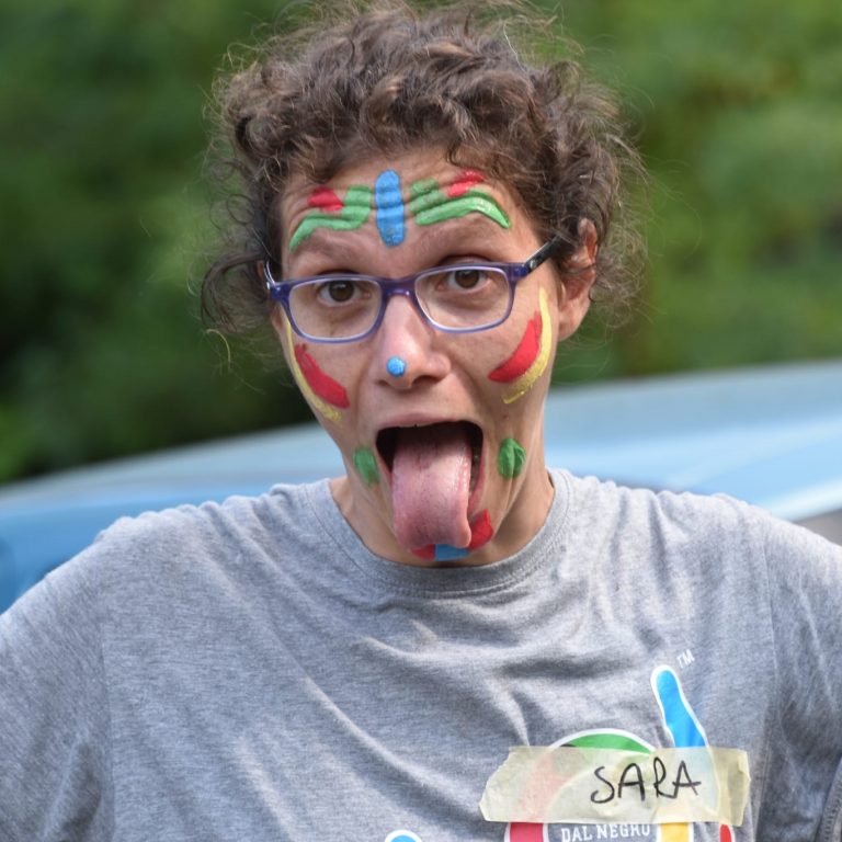 Donna con faccia dipinta e occhiali, divertente espressione.