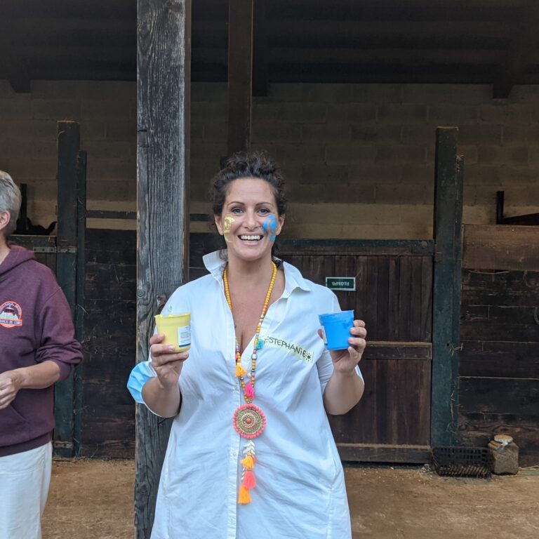 Donna sorridente con tazze colorate in un contesto festivo